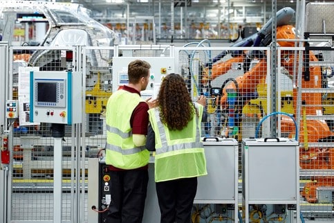 Rear view of engineers working in car plant